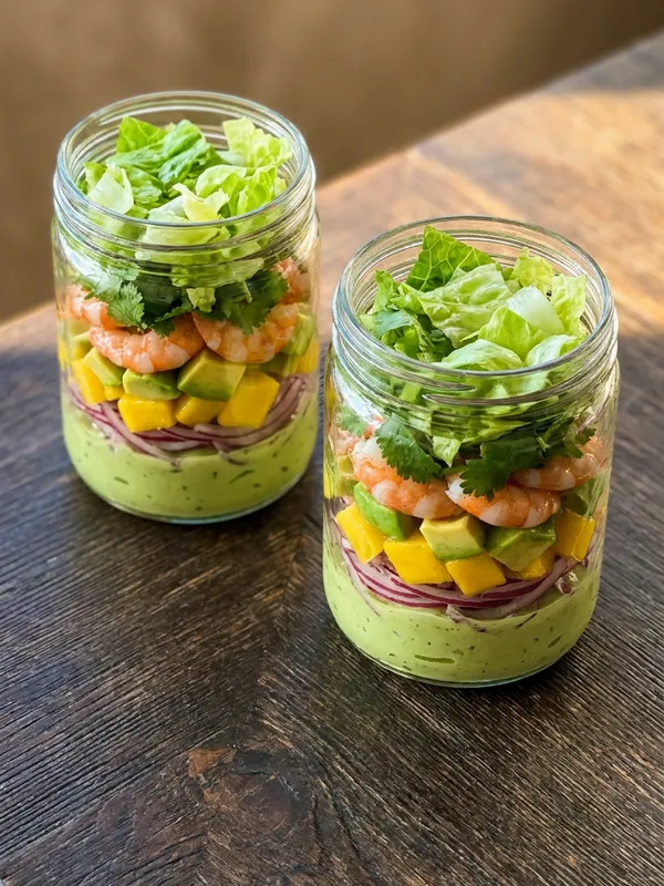 Dois potes de salada de camarão com abacate e manga